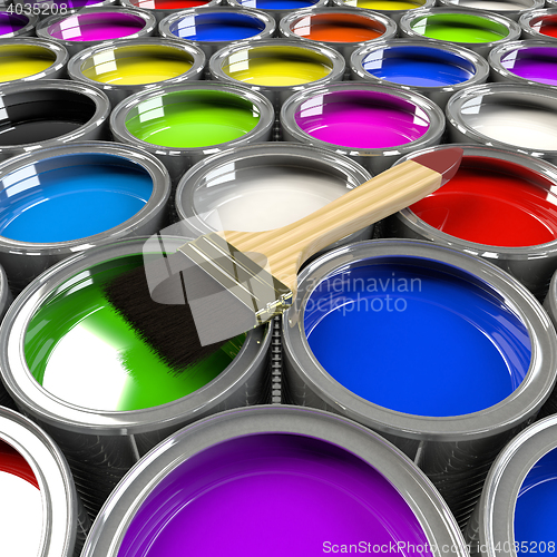 Image of Multiple open paint cans with a brush. 