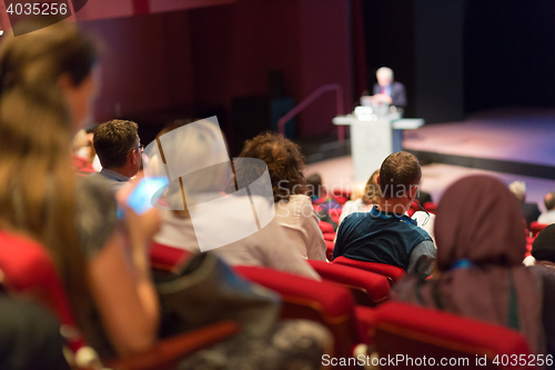 Image of Business speaker giving a talk in conference hall.