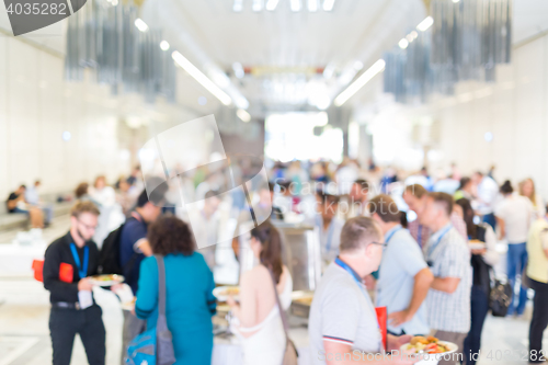 Image of Abstract blurred people socializing during lunch break at business conference.