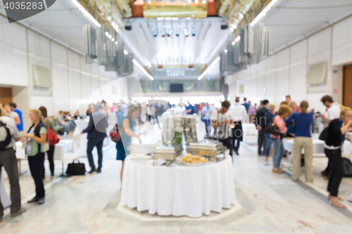 Image of Abstract blurred people socializing during lunch break at business conference.