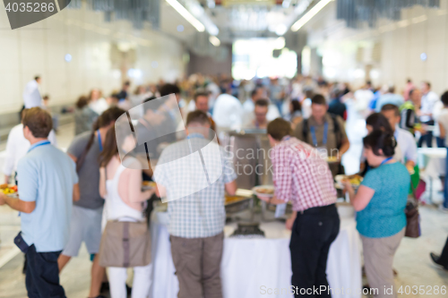 Image of Abstract blurred people socializing during lunch break at business conference.