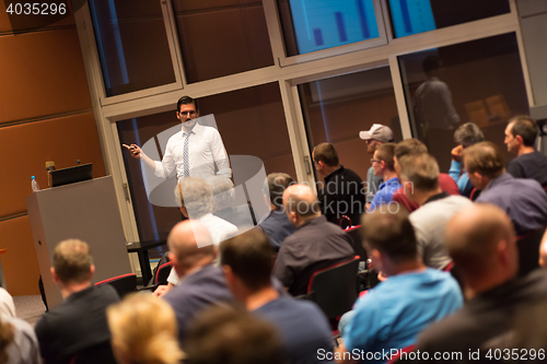 Image of Business speaker giving a talk in conference hall.