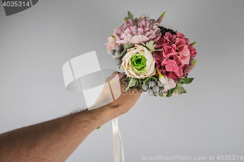 Image of male hand giving wedding bouquet