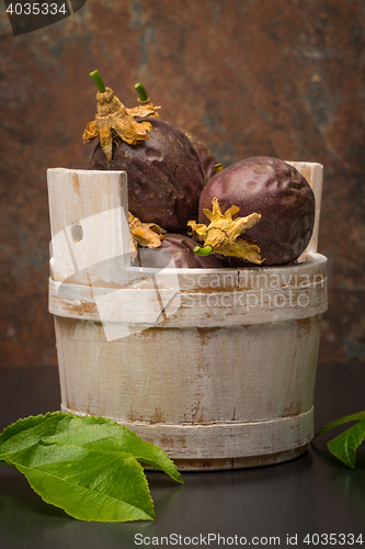 Image of Passion fruits s on a wooden bucket