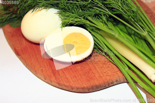 Image of sliced boiled egg, green onions and dill