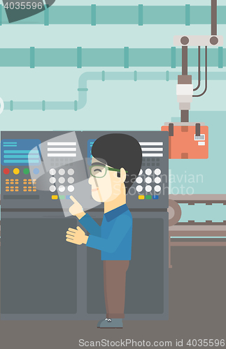 Image of Engineer standing near control panel.