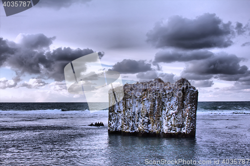 Image of Pole in ocean. Rock with vertical walls. Basaltic parting, 