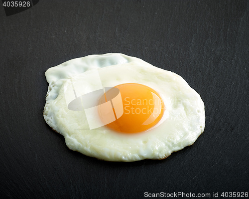 Image of fried egg on black background