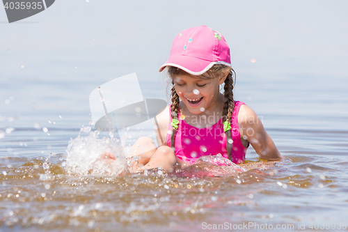 Image of Girl splashing in cap sitting on a shelf in water