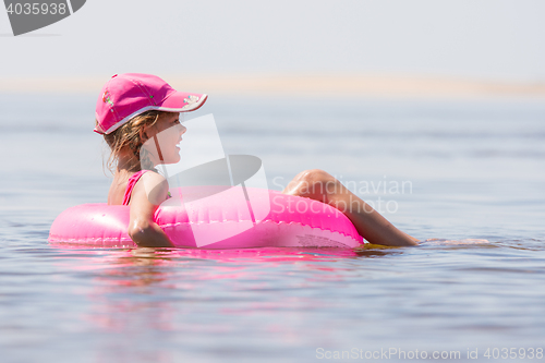 Image of The girl in the cap swim in the river sat on the swimming circle