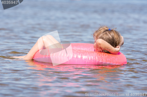 Image of Five-year girl swims in the river sat on the swimming circle