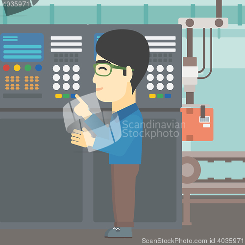 Image of Engineer standing near control panel.