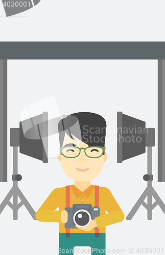 Image of Photographer with camera in photo studio.