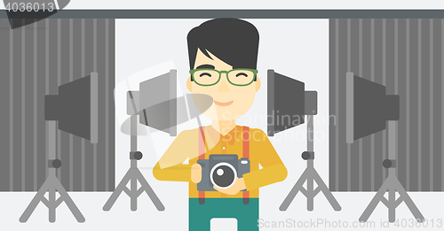 Image of Photographer with camera in photo studio.