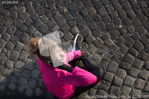 Image of woman  stretching before morning jogging