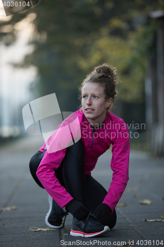 Image of woman  stretching before morning jogging