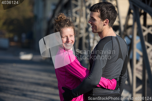 Image of couple warming up before jogging