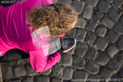 Image of woman  stretching before morning jogging