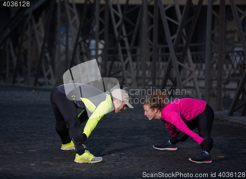 Image of couple warming up before jogging