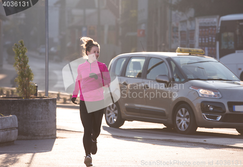 Image of sporty woman jogging on morning