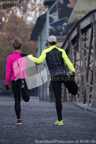 Image of couple warming up before jogging