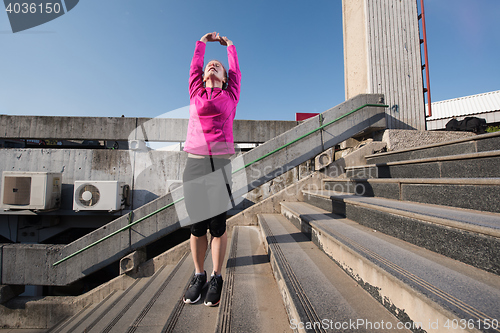 Image of woman  stretching before morning jogging