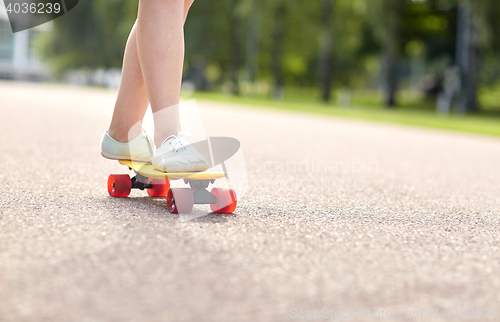 Image of close up of female feet riding short skateboard