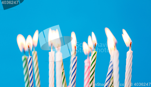 Image of birthday candles burning over blue background