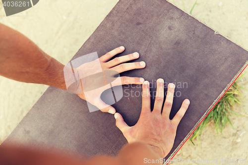 Image of close up of man hands exercising on bench outdoors