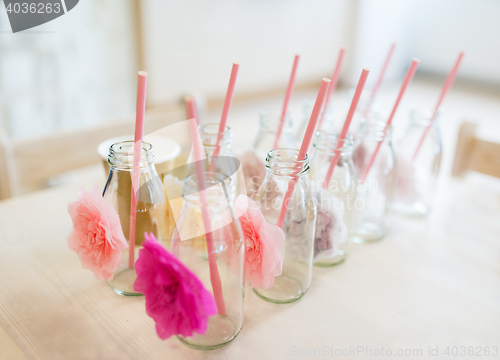 Image of close up of glass bottles for drinks with straws