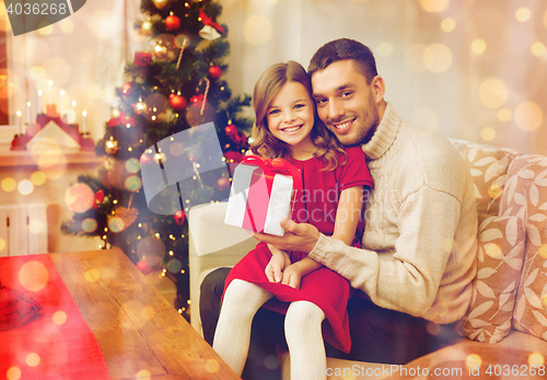 Image of smiling father and daughter holding gift box