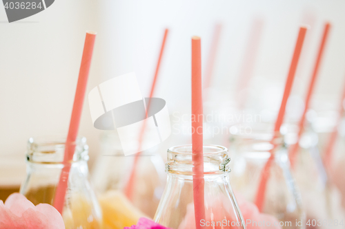 Image of close up of glass bottles for drinks with straws