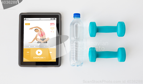 Image of close up of tablet pc, dumbbells and water bottle