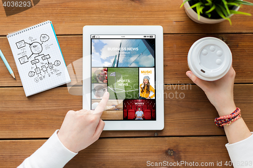 Image of close up of woman with tablet pc on wooden table
