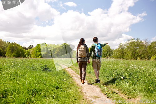 Image of happy couple with backpacks hiking outdoors