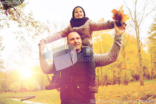 Image of happy family having fun in autumn park