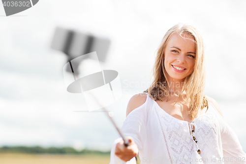 Image of happy young woman taking selfie by smartphone