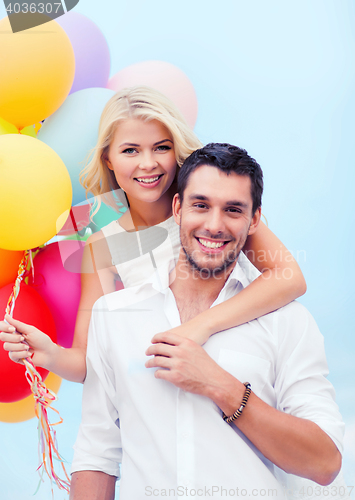 Image of couple with colorful balloons at seaside