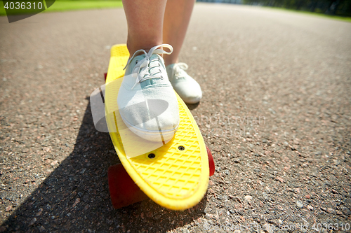 Image of close up of female feet riding short skateboard