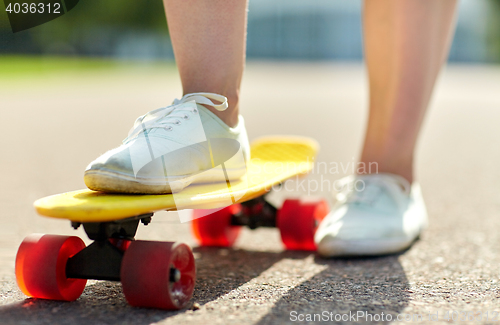 Image of close up of female feet riding short skateboard