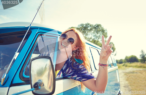 Image of smiling young hippie woman driving minivan car