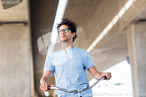 Image of young hipster man riding fixed gear bike