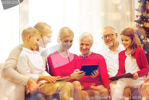 Image of smiling family with tablet pc computers at home