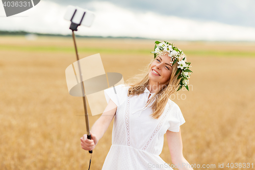 Image of happy young woman taking selfie by smartphone