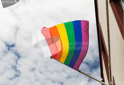 Image of close up of rainbow gay pride flag waving on building