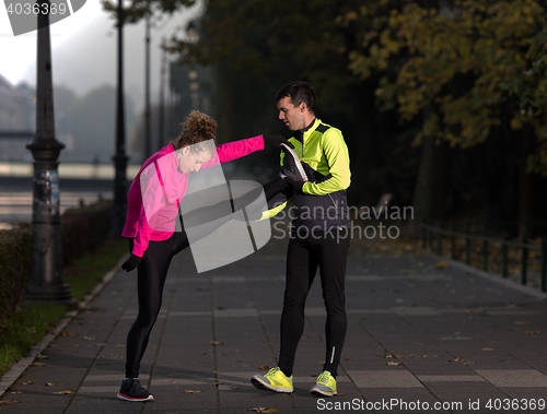 Image of couple warming up before jogging