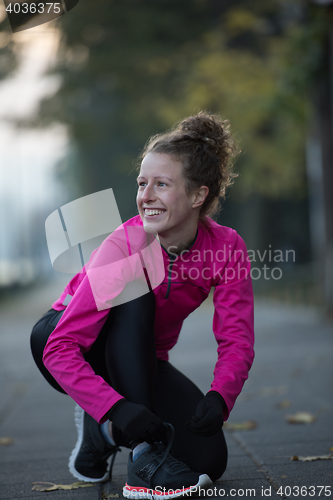 Image of woman  stretching before morning jogging