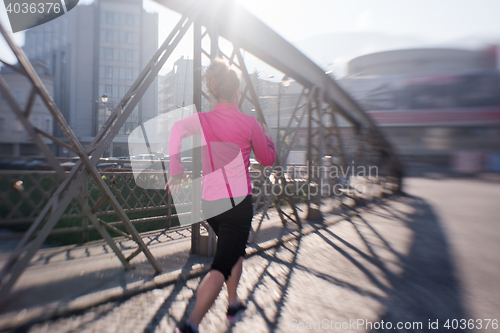 Image of sporty woman jogging on morning