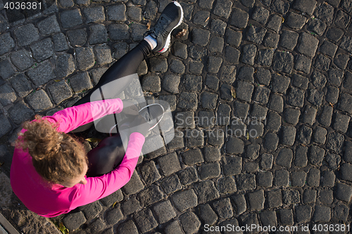 Image of woman  stretching before morning jogging