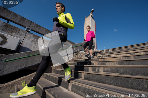 Image of young  couple jogging on steps